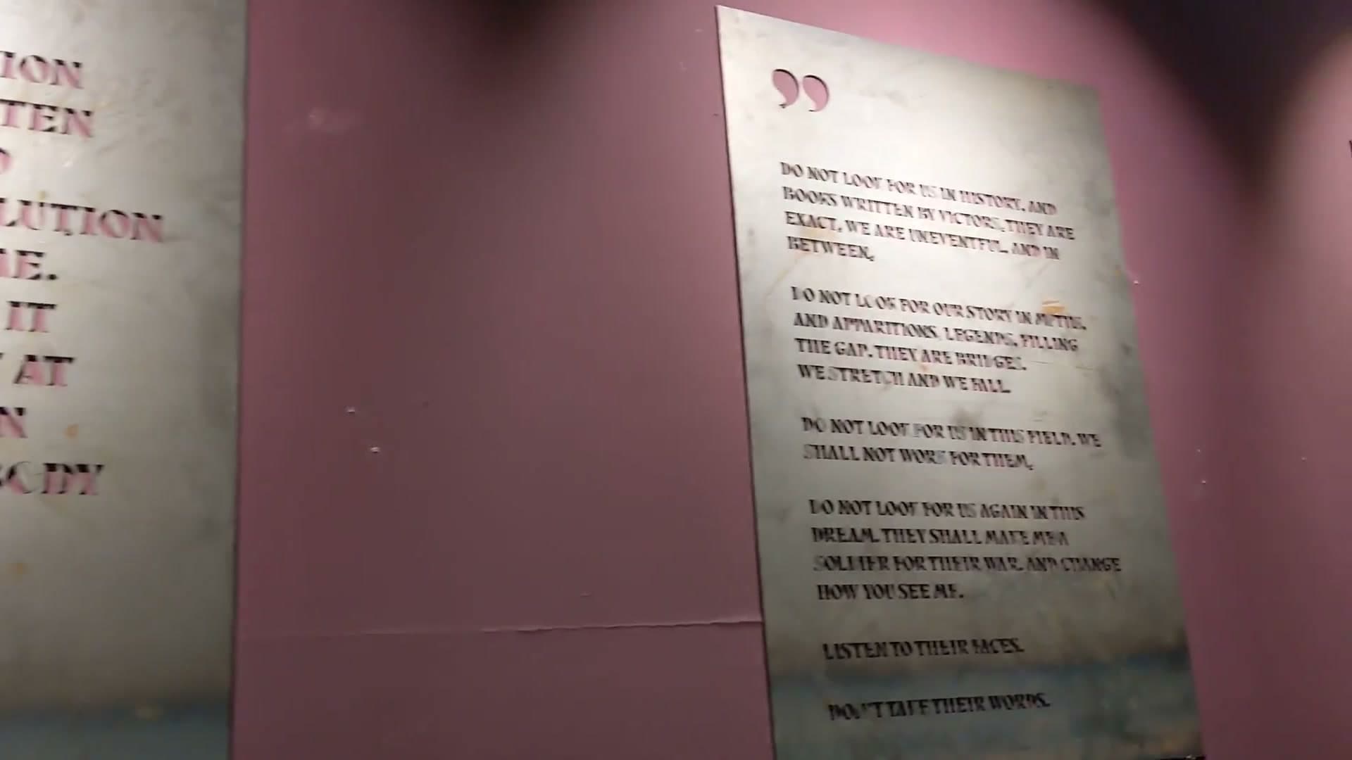 Pink gallery walls with poetry and text panels